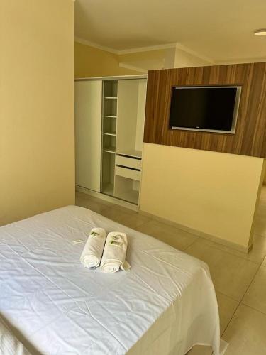 ein Schlafzimmer mit einem Bett mit zwei Handtüchern darauf in der Unterkunft KITNET 1001 Apart Hotel in Piracicaba