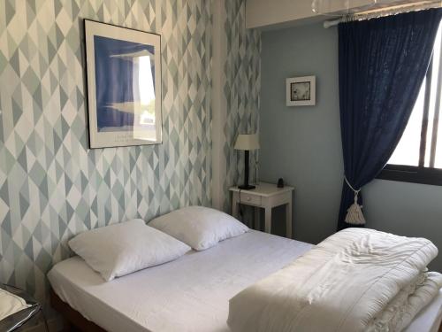 une chambre avec un lit et un miroir au mur dans l'établissement Appartement T2 refait à neuf avec balcon face mer et ascenseur, au cœur des Sables-d'Olonne - FR-1-485-70, à Les Sables-dʼOlonne