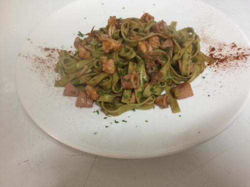 a white plate of food with pasta and meat at HOTEL CASA AMARILLA et RESTAURANT in Punta Chame