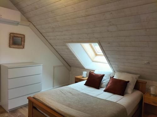 a attic bedroom with a bed and a skylight at Gîte spacieux à Saint-Léon avec clim et parking - FR-1-489-437 in Saint-Léon