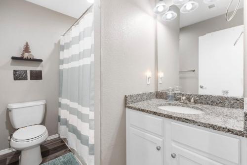 a bathroom with a white toilet and a sink at Spruce Valley in Branson