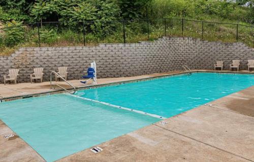 an empty swimming pool with chairs and a rock wall at Spruce Valley in Branson