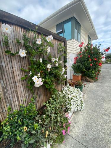 a fence with flowers on the side of a house at Opononi Lighthouse Motel in Opononi