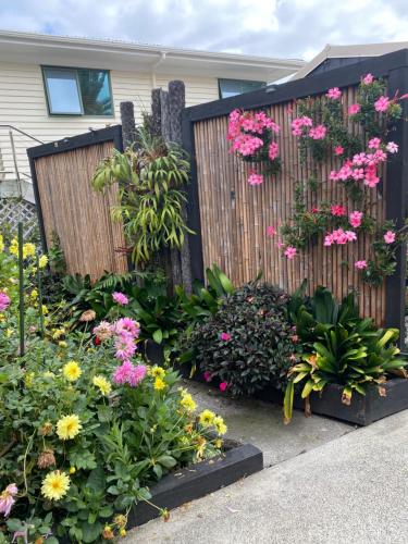 a garden with flowers and a fence at Opononi Lighthouse Motel in Opononi