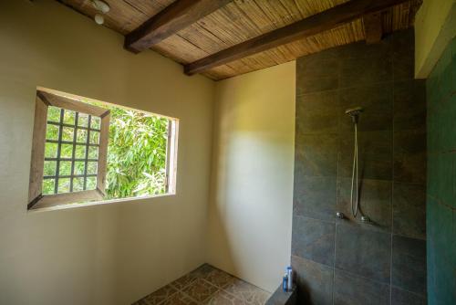 ein Bad mit einer Dusche und einem Fenster in der Unterkunft Paraiso Perdido in Mompiche