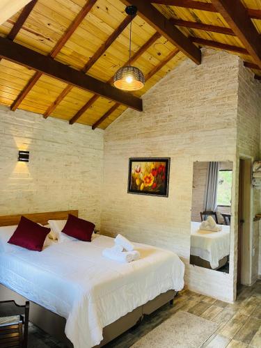 a bedroom with two beds in a room at Chalé Recanto dos Pinheiros in Monte Verde