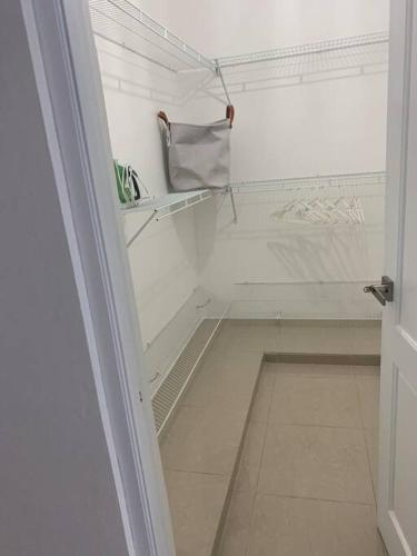 una puerta abierta de un armario blanco con un estante en Residencial joyas d’ luxe lll en Santiago de los Caballeros