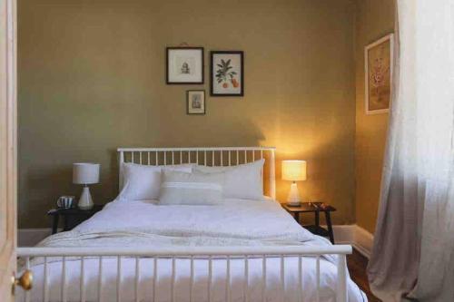 1 dormitorio con 1 cama blanca grande y 2 lámparas en The Shooters Cottage Bellerive I Circa 1830, en Bellerive