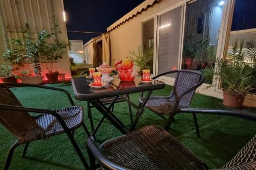 einen Tisch und Stühle auf einer Terrasse in der Nacht in der Unterkunft Modernistic Antique Stay in Dschidda