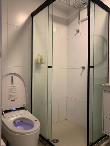 a bathroom with a toilet and a glass shower at Studio Automatizado ao lado da Av. Paulista in São Paulo