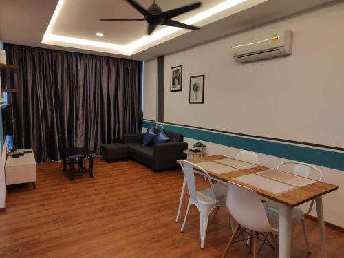 uma sala de estar com uma mesa e um sofá em H. S. Tang's Homestay J1 em Kuching
