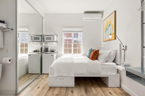 a white bedroom with a bed and a kitchen at The Varden - A Boutique Micro Hotel - #25 in Long Beach