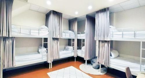 a room with four bunk beds with curtains and a room at Taitung Puyuma Style Inn in Taitung City