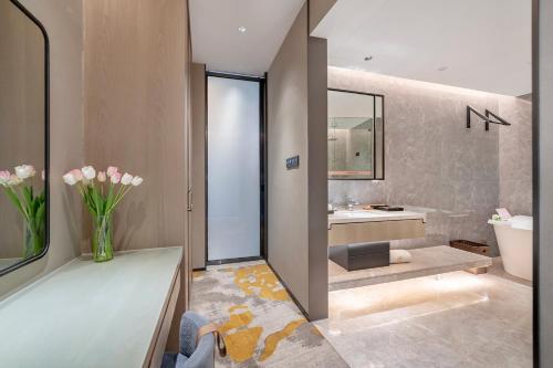 a bathroom with a tub and a toilet and a sink at Evwa Platinum Hotel in Huizhou