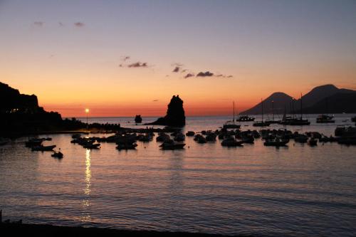 a group of boats in the water at sunset at Dolcevita Villa in Vulcano in Vulcano