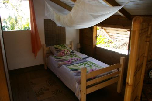 - une chambre avec un lit dans une pièce dotée d'une fenêtre dans l'établissement Kaz Créole Jardin et Jacuzzi Privés, à Saint-François