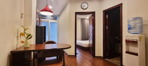 a dining room with a table and a room with a clock at Ruby Serviced Apartment Liễu Giai in Hanoi