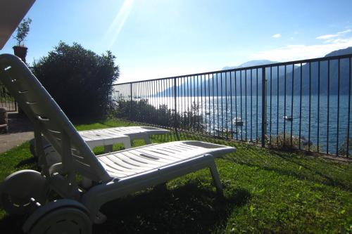 a bench sitting on the grass near the water at B&B Casa Sartori in Malcesine