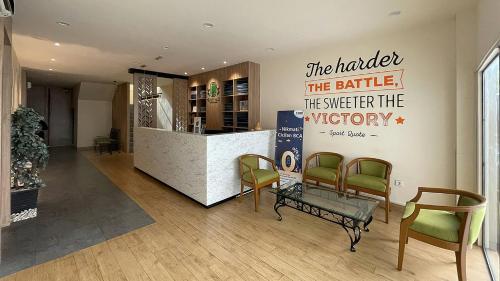 a lobby with a bar with a sign on the wall at Emerald Garden International Hotel in Medan