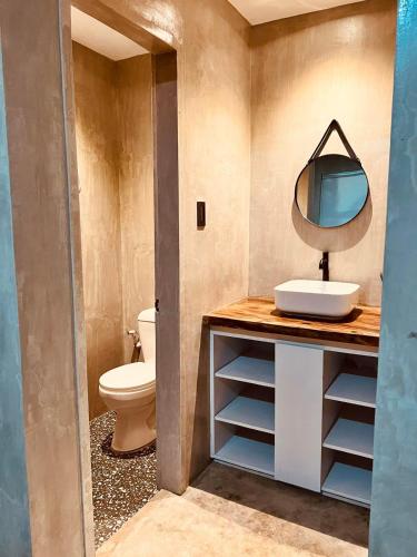 a bathroom with a sink and a mirror on a counter at Beach People Hostel Bantayan Island in Ocoy