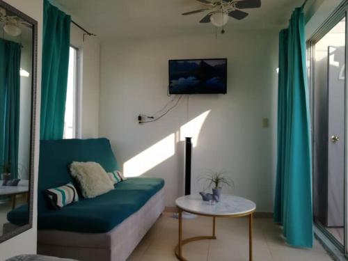 ROOF G BELLO HORIZONTE في Emiliano Zapata: غرفة معيشة مع أريكة زرقاء وطاولة