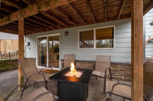 a fire pit on a patio with chairs and a house at A Taste Of Dundee in Dundee