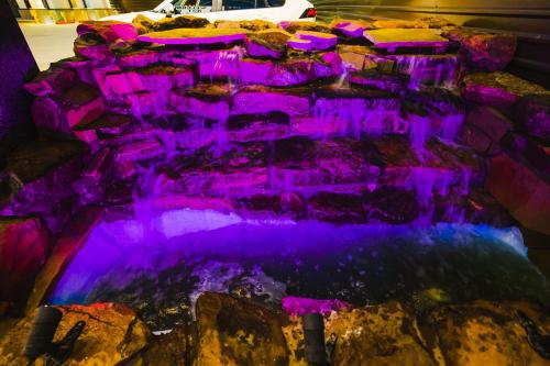 a waterfall lit up with purple lights at Downtowner Inns - Houston Downtown & Convention Center in Houston