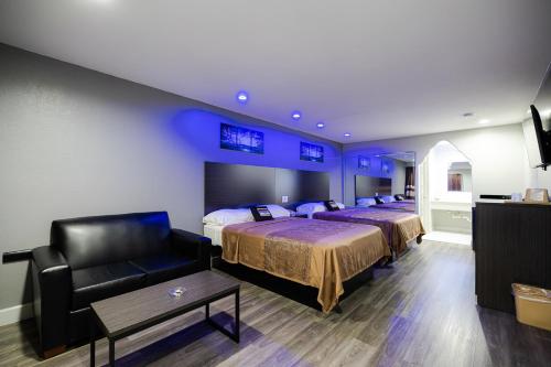 a hotel room with two beds and a couch at Downtowner Inns - Houston Downtown & Convention Center in Houston