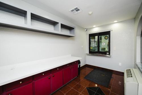 a kitchen with red cabinets and a window at Downtowner Inns - Houston Downtown & Convention Center in Houston