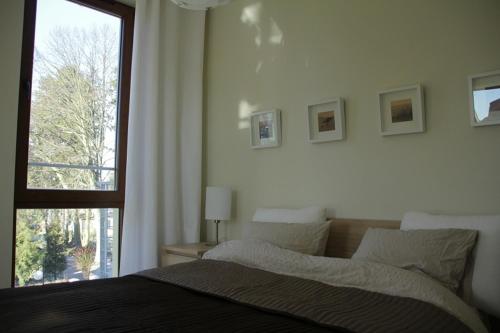 a bedroom with a bed and a large window at Apartament Morski in Rewal