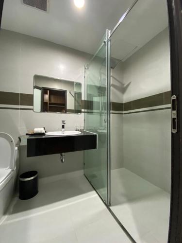 a bathroom with a glass shower and a sink at ĐTT Galaxy Tam Chúc in Ðục Khê