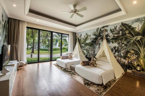 two beds in a room with a large window at Vinpearl Wonderworld Phu Quoc in Phu Quoc