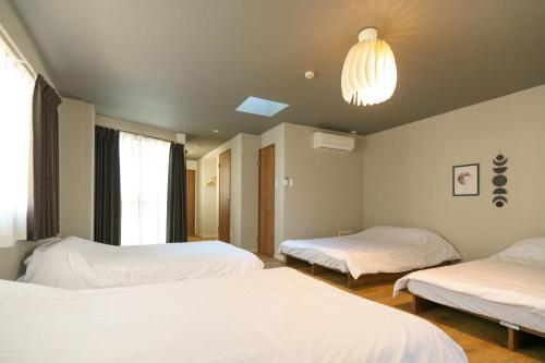 名古屋市にある自由自在OSU 501(SORA)のベッド2台とシャンデリアが備わる客室です。