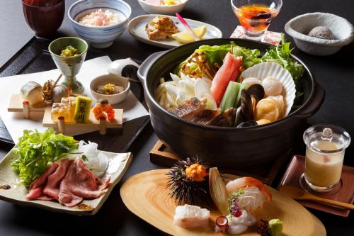 una mesa cubierta con platos de comida y un plato de sushi en La Vista Akangawa, en Akankohan