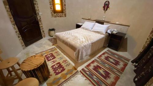 a bedroom with a bed and a table and a chair at Grand Siwa in Siwa