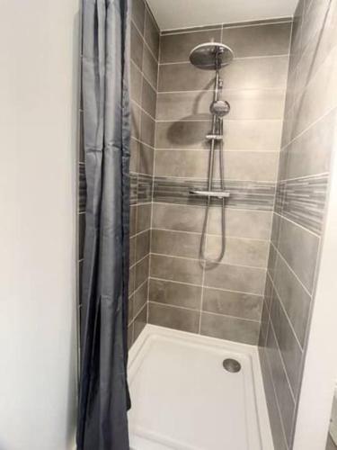 une douche avec un rideau de douche dans une salle de bain dans l'établissement SUPER Studio Tout équipé WIFI 2PERS, à Saint-Quentin