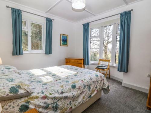 sypialnia z łóżkiem i 2 oknami w obiekcie Bron Aber w mieście Arthog