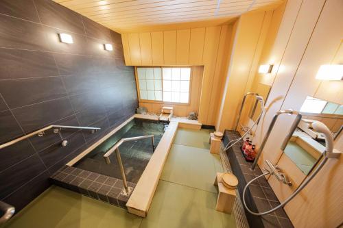 a large bathroom with a swimming pool in it at サポートイン南知多 in Utsumi