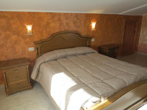 a bedroom with a large bed and a night stand at Albergo Little Garden in Formia