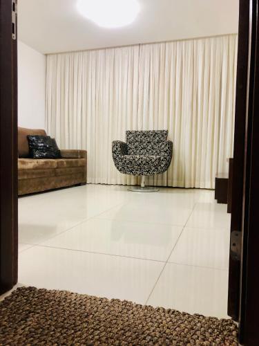 a living room with a couch and a chair at Tambaú Home Beira Mar - com varanda in João Pessoa