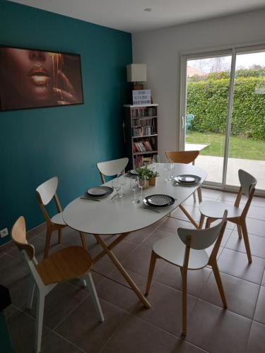 una sala da pranzo con tavolo e sedie bianchi di Maison BELIZO, familiale ,calme et reposante. a Vernet