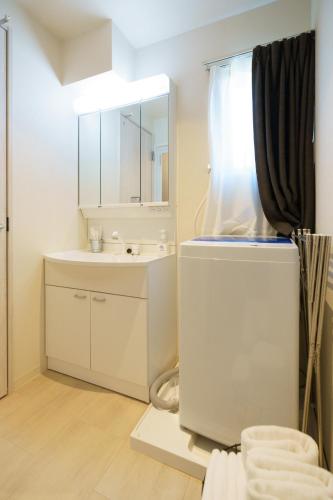 a white bathroom with a sink and a mirror at 自由自在OSU 401(NIJI) in Nagoya