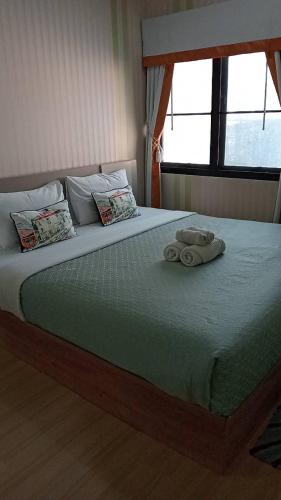 a bedroom with a large bed with two towels on it at Peters Villa in Ban Nakhon Chum