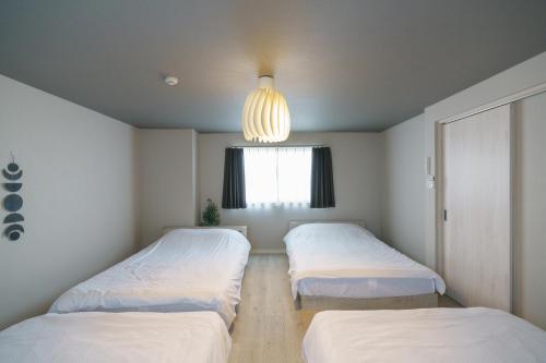 1 dormitorio con 2 camas y lámpara de araña en 自由自在OSU 302(TORI), en Nagoya