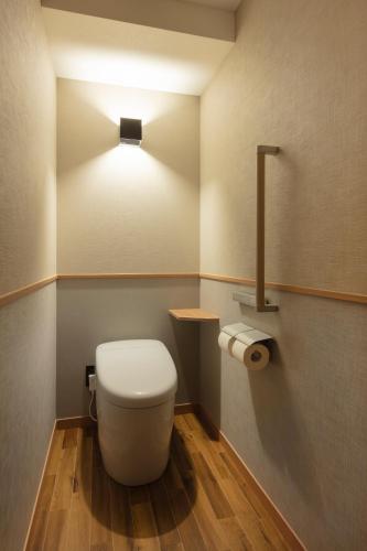 a bathroom with a toilet with a light above it at Matsushima Ichinobo in Matsushima