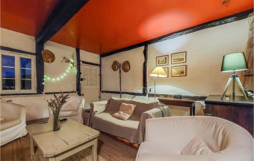 Elle comprend un salon doté d'un mobilier blanc et d'un mur orange. dans l'établissement 3 Bedroom Awesome Home In Normanville, à Normanville