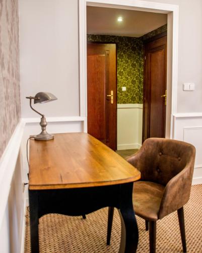 a desk with a lamp and a chair in a room at Grand Częstochowa in Częstochowa
