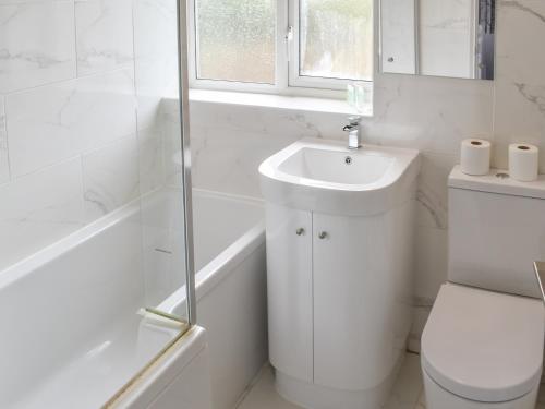 a white bathroom with a toilet and a sink at Briar Cottage in Knaresborough