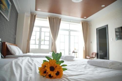 um quarto de hotel com uma flor amarela numa cama em Hoa Hướng Dương Hotel em Phan Rang-Tháp Chàm