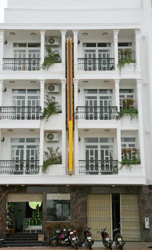 a tall white building with motorcycles parked in front of it at Hoa Hướng Dương Hotel in Phan Rang
